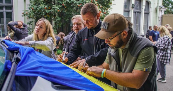 Участники проекта поставили подписи на государственном флаге Украины. Его планируют реализовать на аукционе. Вырученные средства пойдут на приобретение автомобиля для подразделения ПВО и психологическую реабилитацию военных