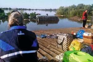 Жительки Нової Каховки на Херсонщині вилізли на дах будівлі, щоб урятуватися від повені, яка почалася після руйнування дамби Каховської гідроелектростанції, 7 червня 2023 року