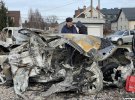 Люди рассматривают собственные авто которые были уничтожены российскими ракетами