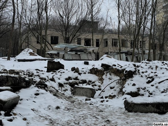 Вирва від вибуху. За нею - будівля дитячого садочка