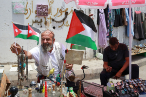 Лагерь для беженцев из Палестины недалеко от Аммана. Мужчина устанавливает флаги Иордании рядом с палестинским в знак солидарности