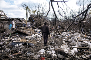 Чоловік дивиться на зруйнований будинок після російського обстрілу в селищі Очеретине на Донеччині 21 лютого