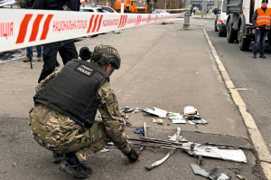 Поліцейські дивляться на пошкоджену будівлю після російського ракетного обстрілу 20 грудня 2024 року в Києві. Внаслідок удару у трьох районах пошкоджено будівлі та транспорт. Одна особа загинула, ще дев’ять отримали поранення