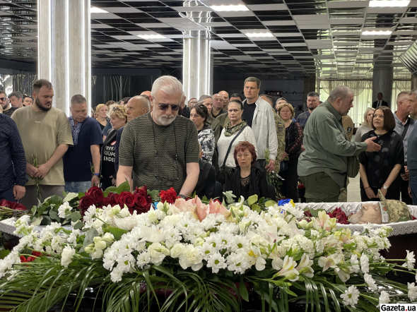 Участники церемонии подходят к гробу, чтобы попрощаться с погибшим бойцом
