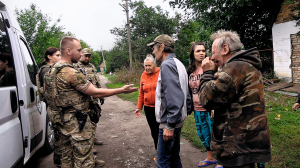 Цивільні стоять біля автівки евакуаційного підрозділу ”Білі янголи”. Люди не хочуть евакуйовуватися, натомість прагнуть поїхати в Павлоград по матеріальну допомогу. Просяна, вересень 2025 року