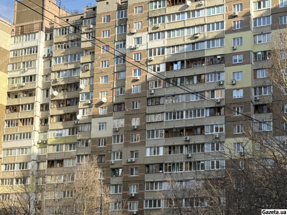 На крышах автомобилей возле соседних домов мелкие обломки стекла и фасад