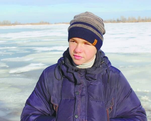 Богдан Волик стоїть на березі річки, де під кригу провалилися двоє 8-річних дівчат