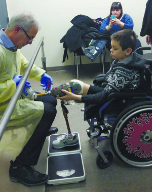 Микола Нижниковський приміряє протези. Навчився ходити на них і штовхати м’яча