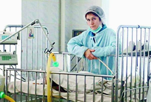 Віталіна Сімченко стоїть біля лікарняного ліжка доньки Вероніки. В дівчинки раптово посиніла кисть правої руки. Лікарі наполягли на ампутації кінцівки
