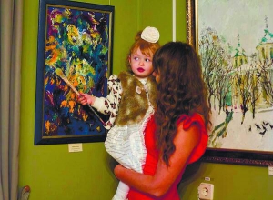 Тетяна Охріменко з Дніпра тримає на руках доньку Ніку Стрілецьку. У музеї українського живопису відкрилася виставка дівчинки