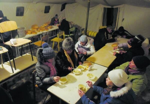 Мешканці Авдіївки отримують їжу в рятувальників у мобільному пункті обігріву після обстрілу міських будівель 31 січня