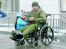 Чоловік в інвалідному візку з дитиною беруть участь у прощанні з сімома українськими військовими, які загинули під Авдіївкою
