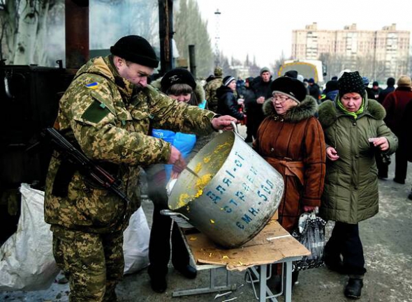 Жителі Авдіївки їдять у мобільному пункті обігріву після обстрілу міста 3 лютого. Пропонують кашу, суп і чай