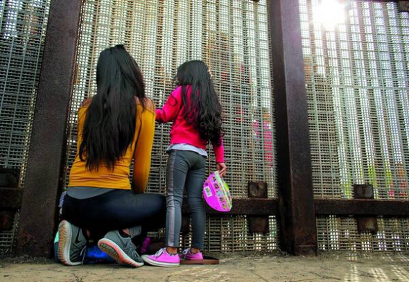 Розділені родичі розмовляють на американсько-мексиканському кордоні в Каліфорнії