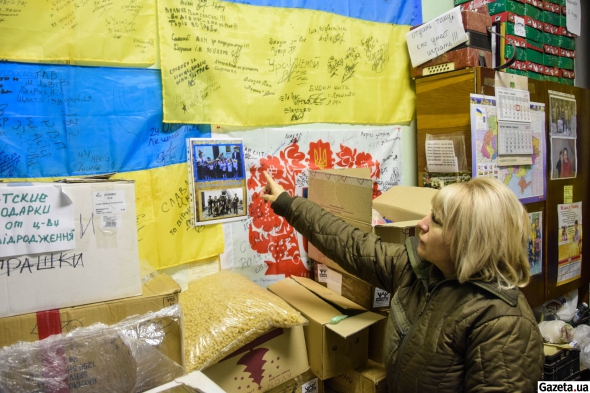 Лариса Когут показує на блакитно-жовтий прапор, який їй розписали бійці