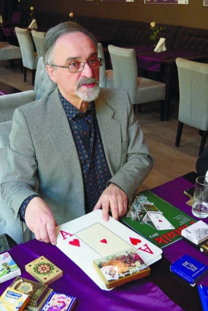 Юрій Рисс сидить в одному з львівських ресторанів. На столі розклав частину своєї колекції гральних карт. Найбільші — розміром з аркуш паперу