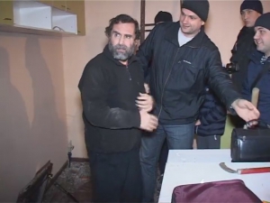 Валерій Людмирський іде у супроводі правоохоронців після звільнення. Його викрали в липні торік