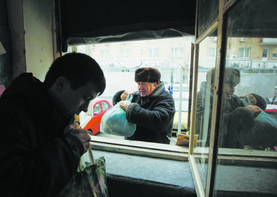 Чоловік жертвує одяг волонтерському центру ”Кожен може допомогти” в Києві 6 грудня 2014-го. Допомагають переселенцям із Донбасу, українським військовим і тим, хто лишився жити на окупованій території. Роздають їжу, одяг, побутову хімію та ліки