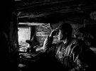 Змучений український солдат спостерігає за ворожими позиціями з імпровізованого бункера на позиції в передньому краї, в секторі Маріуполя, квітнь 2017 року