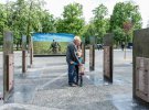 Маленькая девочка с дедушкой возле открытого мемориального комплекса