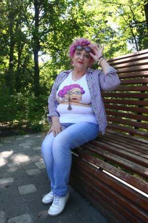 Степанида Цвіт сидить на лавці у столичному ботанічному саду. Вона вдягається в молодіжному стилі, волосся фарбує у яскраві кольори. Свої фото викладає в ”Інстаграм”