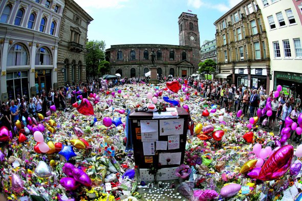 Люди приносять квіти до імпровізованого меморіалу жертвам теракту на площі Святої Анни в Манчестері, Велика Британія