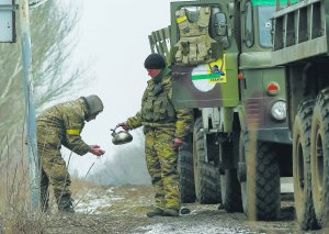 Українські військовослужбовці вмиваються біля міста Бахмут Донецької області 19 лютого 2015 року. Вони виходять із Дебальцівського плацдарму. Активні бої тривали там із 18 січня по 18 лютого. За цей час загинули 179 українських військових, 110 — потрапили в полон, 81 — зник безвісти. Проти 2 500 українських воїнів кинули майже 17 тисяч бійців ворога