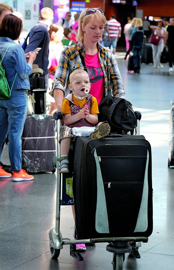 Жінка з сином йде аеропортом ”Бориспіль” 11 червня – в перший день безвізового режиму з ЄС. Пасажирів розважали музиканти й танцювальні колективи