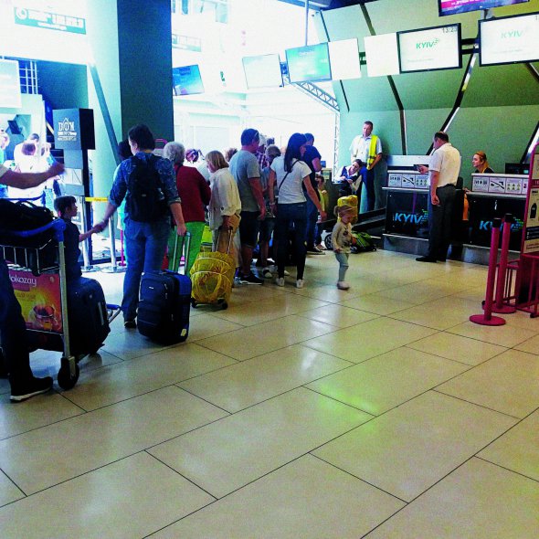 Пасажири стоять у черзі до стійки реєстрації на рейс до білоруського Мінська у столичному аеропорту “Київ” у неділю 25 червня