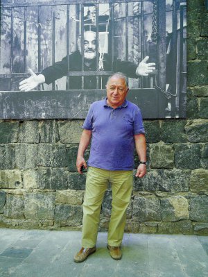 Фотограф Завен Саркісян стоїть біля знімка Сергія Параджанова на подвір’ї музею режисера в Єревані. Чоловік очолює заклад із часу його відкриття 1991 року