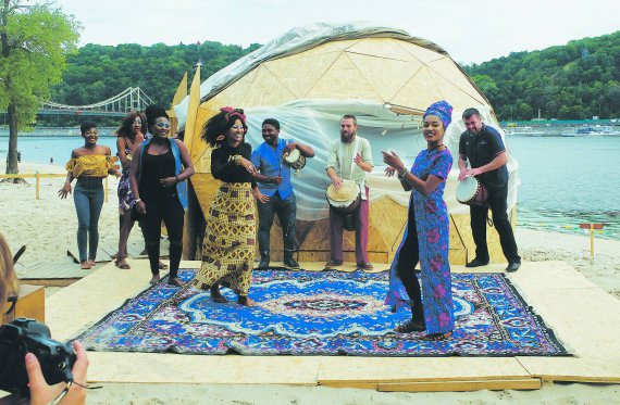 Ганійська дизайнерка Ріта Беніва (праворуч) танцює під час показу її одягу на столичному Трухановому острові. Поєднала традиційний одяг рідної країни з європейським стилем