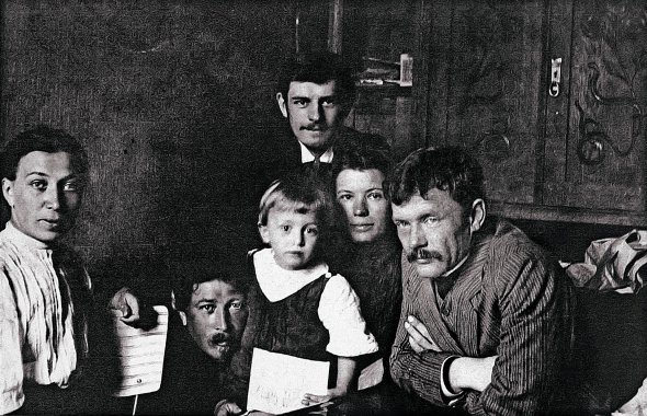 Малий Олег Кандиба (у центрі), його батько Олександр Кандиба (ліворуч, притуляється до сина) – псевдонім Олександр Олесь – і друзі родини, 1910 роки