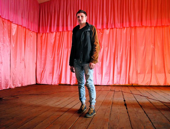 Иван Яринко стоит на сцене клуба в центре Делового. 