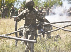 Розвідник бригади тактичного угруповання ”Луганськ” долає смугу перешкод під час змагань на найкращий розвідувальний взвод. Також у рамках конкурсу розвідники знищували умовного противника. Взводи оцінювали за швидкістю подолання смуги перешкод, влучністю стрільби й тактичними діями.