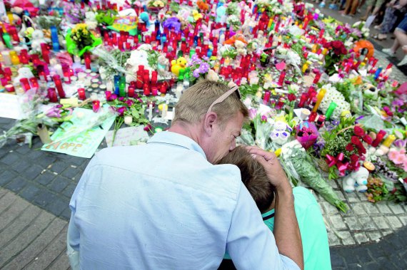 Люди збираються навколо імпровізованого мемо­ріалу ушанувати жертв теракту в іспанській Барселоні. Фургон почавив людей на бульварі Рамбла — головній туристичній вулиці міста — 19 серпня