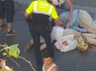 Поліцейський розмовляє з жінкою після теракту на вулиці Рамбла у Барселоні. Серед загиблих — двоє дітей