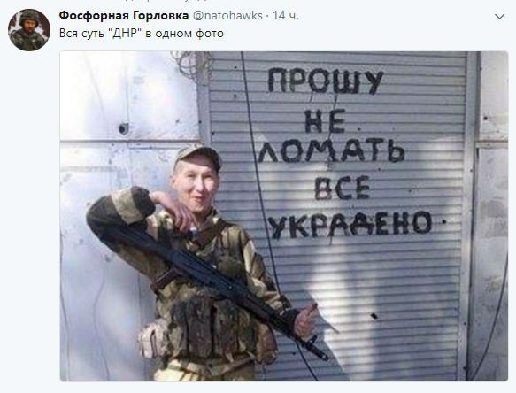Российский наемник позирует возле закрытого офиса в оккупированном Донецке. На дверях - следы от пуль 