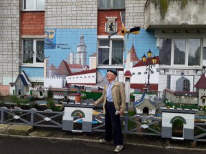 Юрій Краєвський стоїть біля вікон власного будинку у львівському спальному районі Левандівка. Стіни розмалював. На місці клумби поставив копії історичних споруд, що є в центрі міста. Висадив між ними чорнобривці