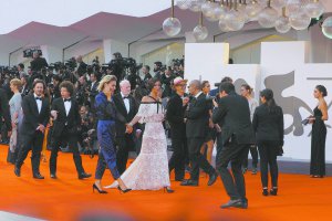 На червоній доріжці церемонії закриття 74-го Венеціанського кінофестивалю члени журі французька актриса Анна Моугаліс (у світлій сукні) та актриса Жасмін Трінка з Італії тримаються за руки