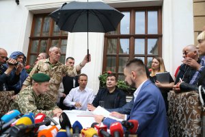 Прикордонники вручають протокол про незаконний перетин українського кордону колишньому голові Одеської обласної державної адміністрації Міхеілу Саакашвілі (на фото по центру) у Львові біля готелю ”Леополіс” 12 вересня. Чекали на нього шість годин. Документ читає адвокат Саакашвілі