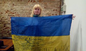 Людмила Сурженко тримає прапор, що росіяни підписували для Збройних сил України 4 березня 2017 року в Москві під час зустрічі зі звільненим із в’язниці політичним активістом Ільдаром Дадіним