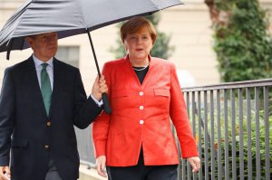 Йоахім Зауер, чоловік канцлера Німеччини Анґели Меркель, тримає над нею парасольку дорогою до виборчої дільниці, 24 вересня 2017 року, Берлін