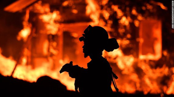 Пожарный наблюдает за горящим зданием в Напа