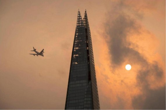 Самолет на фоне неба необычного оранжевого цвета, вызванного ураганом. Лондон.