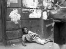Женщина, лежащий на тротуаре в Варшавском гетто, умирает от голода