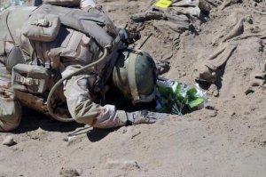 Солдат-шиїт молиться на братській могилі загиблих юнаків