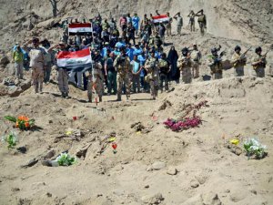 Иракские солдаты салютуют на братской могиле в районе Тикрит
