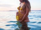 Фотосессия беременной с лепестками на груди и животе