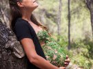 Фотосесія вагітної із пелюстками на грудях і животі