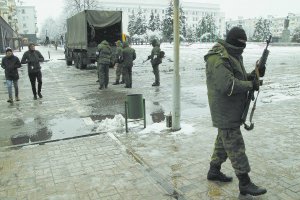 Місцеві мешканці проходять повз озброєних чоловіків у балаклавах і без знаків розпізнавання на вулицях окупованого Луганська 22 листопада